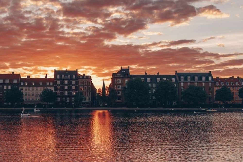 Sunset over one of the Copenhagen Lakes, with the row of lakeside apartment buildings silhouetted against an orange sky