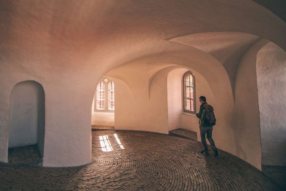 The whitewashed, cobbled spiral ramp curving up inside the Round Tower, lit by small arched windows