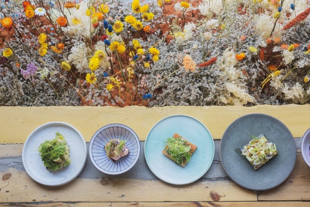 A row of smørrebrød plates beneath a garland of dried flowers at Selma