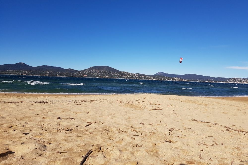Footprints on the sand of the Bouillabaisse beach facing the Maures hills across the gulf