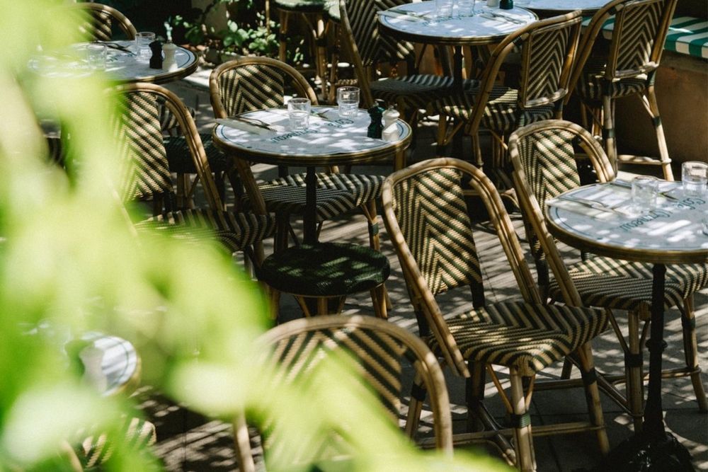 Rattan bistro chairs and marble tables on the terrace of the Café de l'Ormeau, Ramatuelle