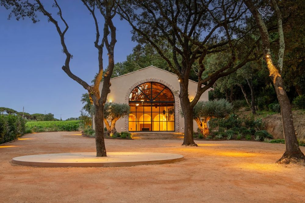 The arched, lit cellar entrance of the Domaine Tropez at dusk