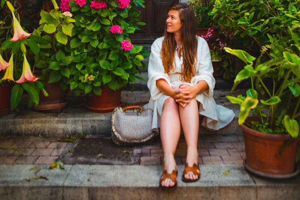 A woman resting on flower-lined steps in a lane of the Vieux-Cannet