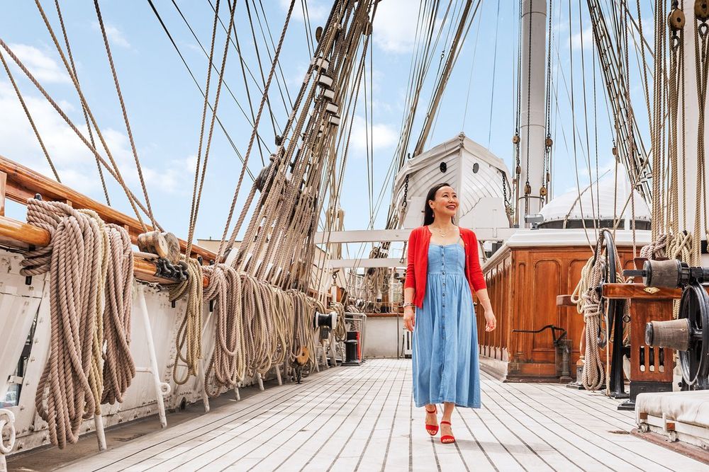A visitor walking the main deck of Cutty Sark between coils of rope and the rigging