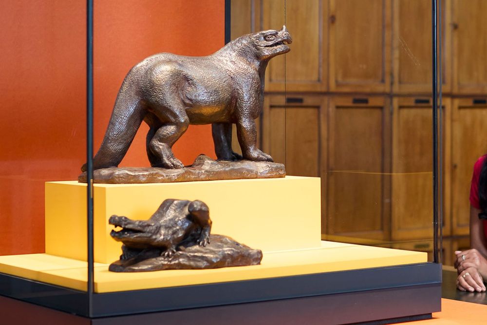 Bronze dinosaur models in a display case at the Natural History Museum