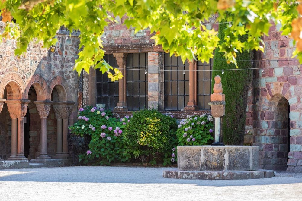 The inner courtyard of the Château de La Napoule with a stone fountain, arches and hydrangeas
