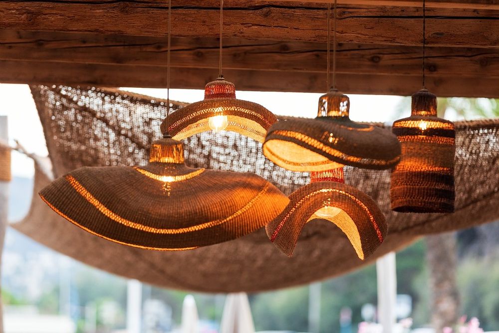 Woven pendant lamps and rope nets hanging under the roof of Playa Chica's beach restaurant