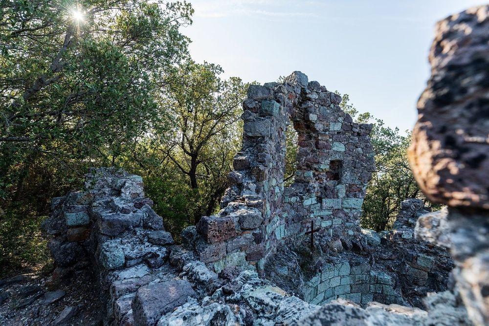 The ruined walls of the old fortress on top of Mont San Peyre among the trees