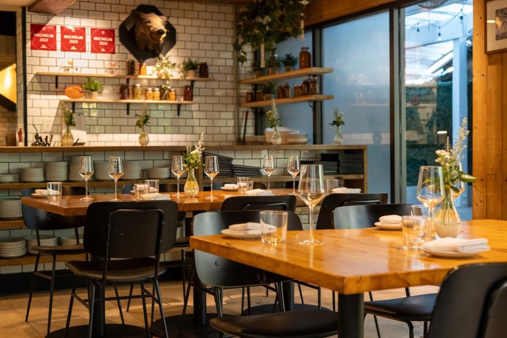 Wooden tables, tiled walls and open shelving in the dining room of Ariete, Coconut Grove