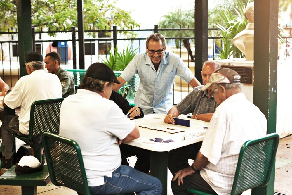 Men playing dominoes at the green tables of Máximo Gómez (Domino) Park on Calle Ocho
