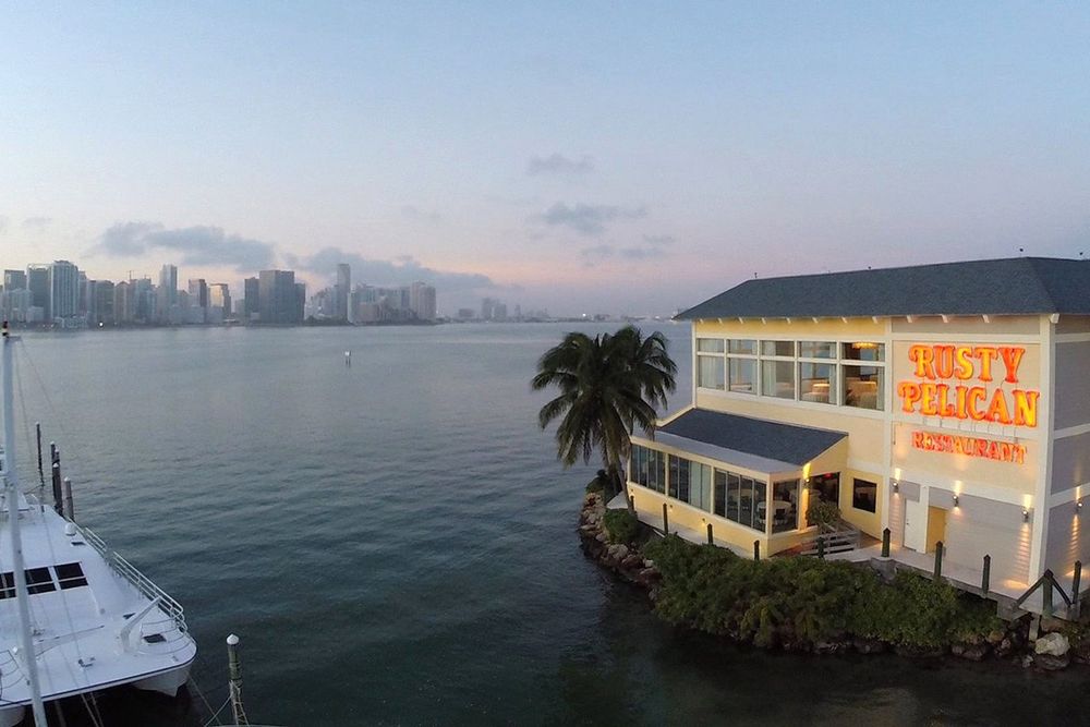 The Rusty Pelican on Virginia Key at dusk, with the Downtown Miami skyline across the bay