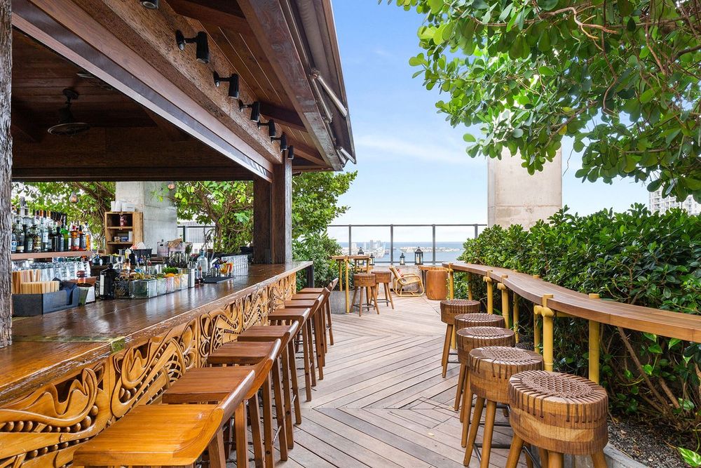The hand-carved wooden bar and decked terrace of Sugar, 40 floors above Brickell, with the bay beyond