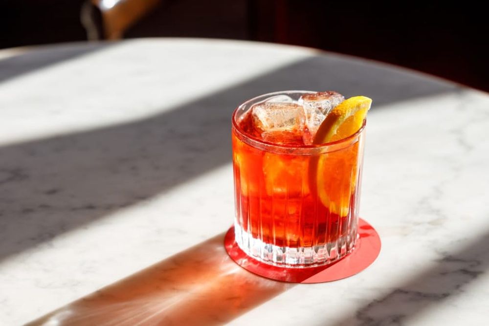 A Campari cocktail with orange on a marble table at Camparino in Galleria
