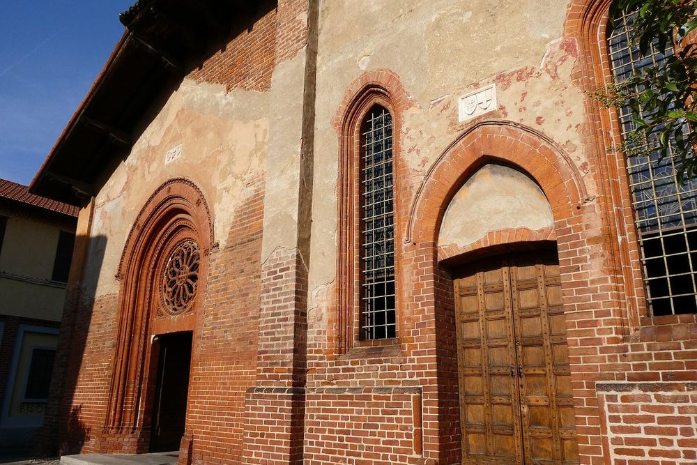 The brick façade and rose window of San Cristoforo sul Naviglio in evening light