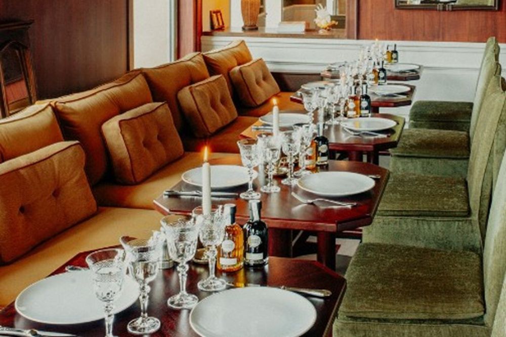 Leather banquettes and laid tables in the warm wood-panelled dining room of Candela at Le Mas Candille