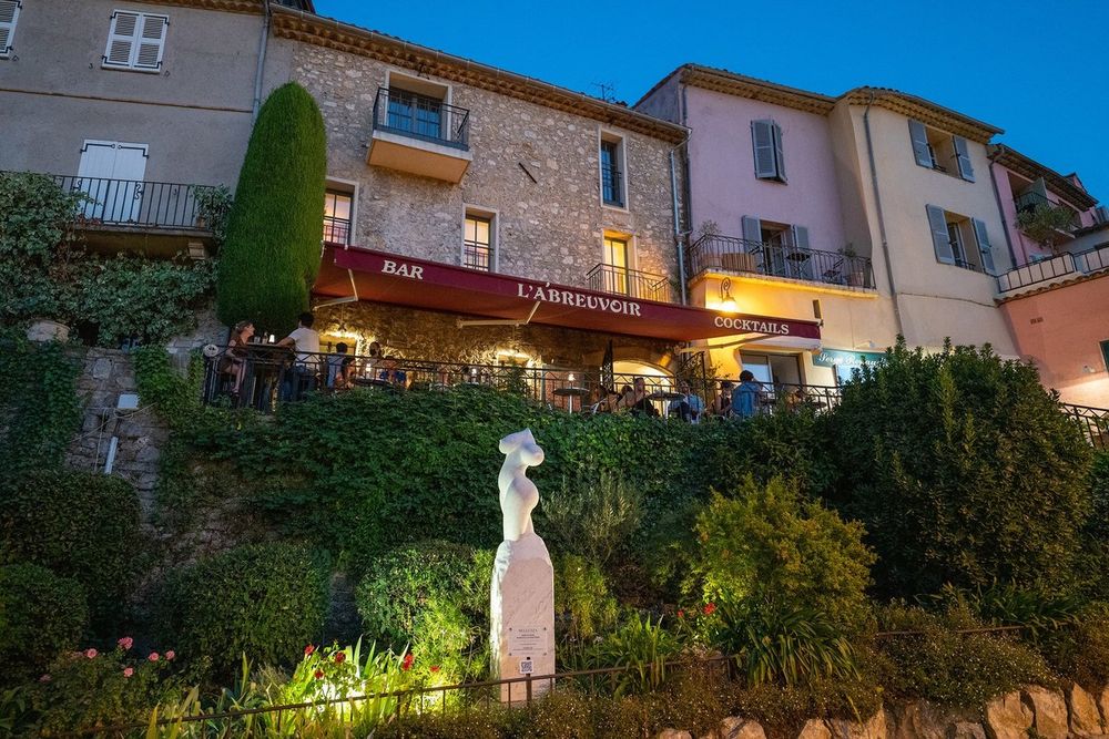 Restaurant terraces and old façades of Mougins village in the evening light