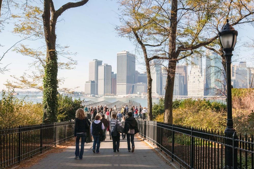 Strollers on the Brooklyn Heights Promenade with the towers of Lower Manhattan beyond