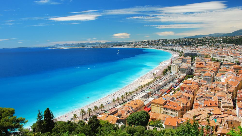 The Baie des Anges in Nice, the pebble beach and the Promenade des Anglais curving along the turquoise sea