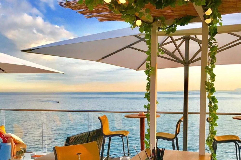 Parasols, vines and high stools on the rooftop of La Réserve de Nice, looking out over the open sea