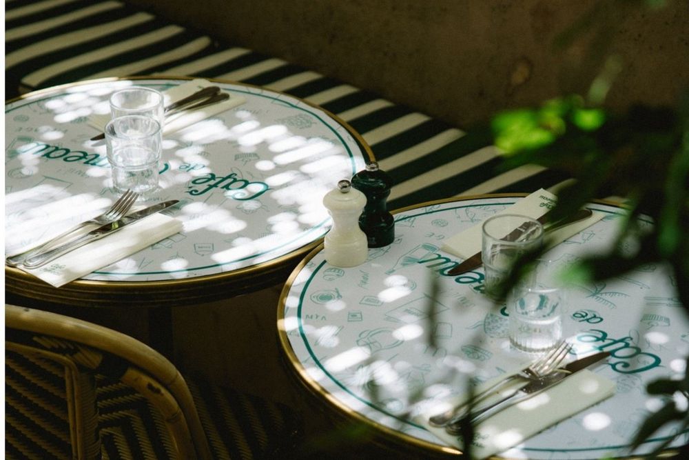 Café de l'Ormeau marble tables in dappled shade on the terrace