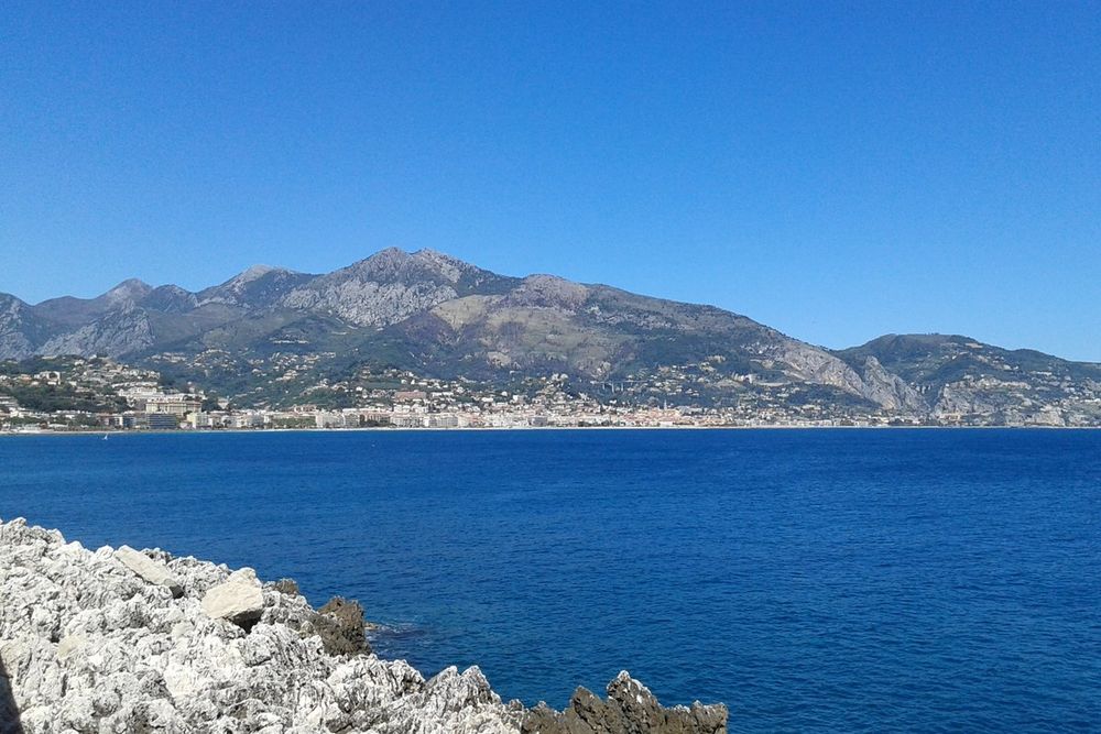 The bay of Menton and its mountains seen across the water from the rocks of Cap Martin