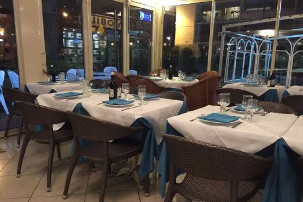 White-clothed tables in the glassed dining room of Le Fellini on the Promenade du Cap, Roquebrune-Cap-Martin