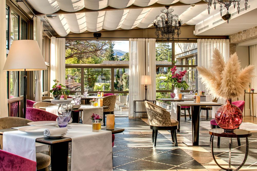 The glass-roofed conservatory dining room of La Table de Pierre at the Domaine du Mas de Pierre