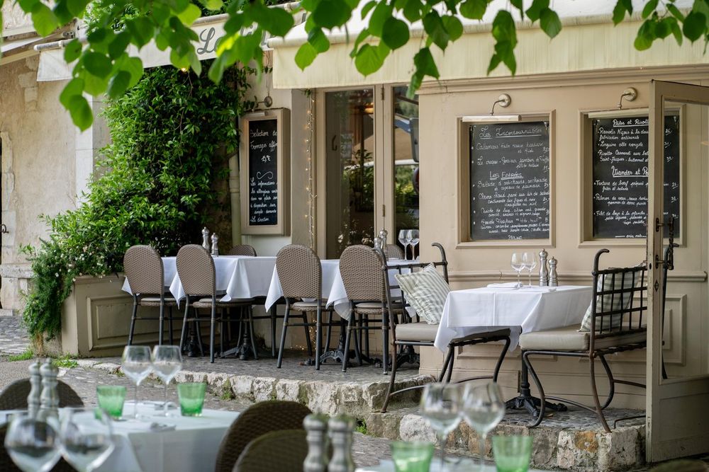 Laid tables on the shaded terrace of Le Tilleul under the lime tree