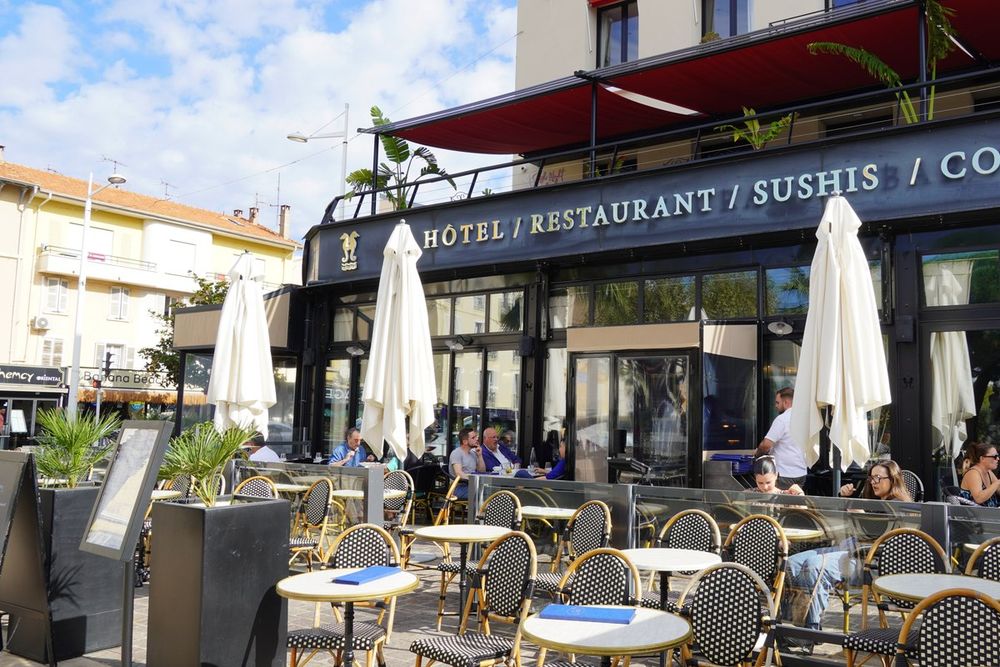 The terrace of Café Touring on the Old Port of Saint-Raphaël, under white parasols