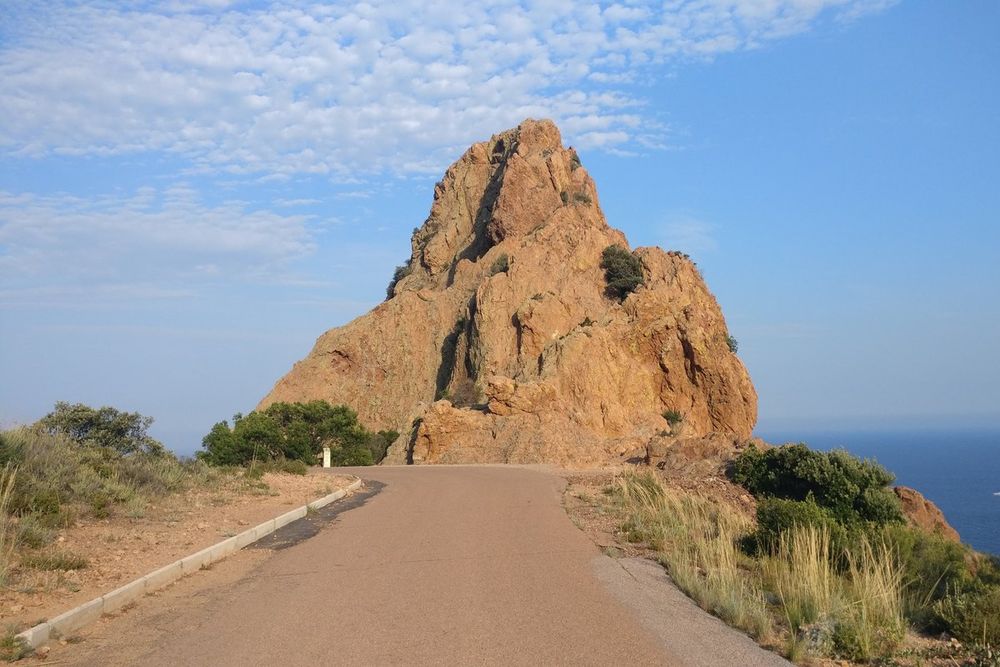 The car-free lane leading to the red Rocher Saint-Barthélemy above the sea in the Estérel
