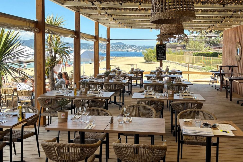 The shaded wooden terrace of 270° by Golfe Azur looking out over the Bouillabaisse beach and the gulf