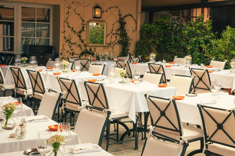 White-clothed tables on the planted terrace of the restaurant at the Hôtel La Ponche