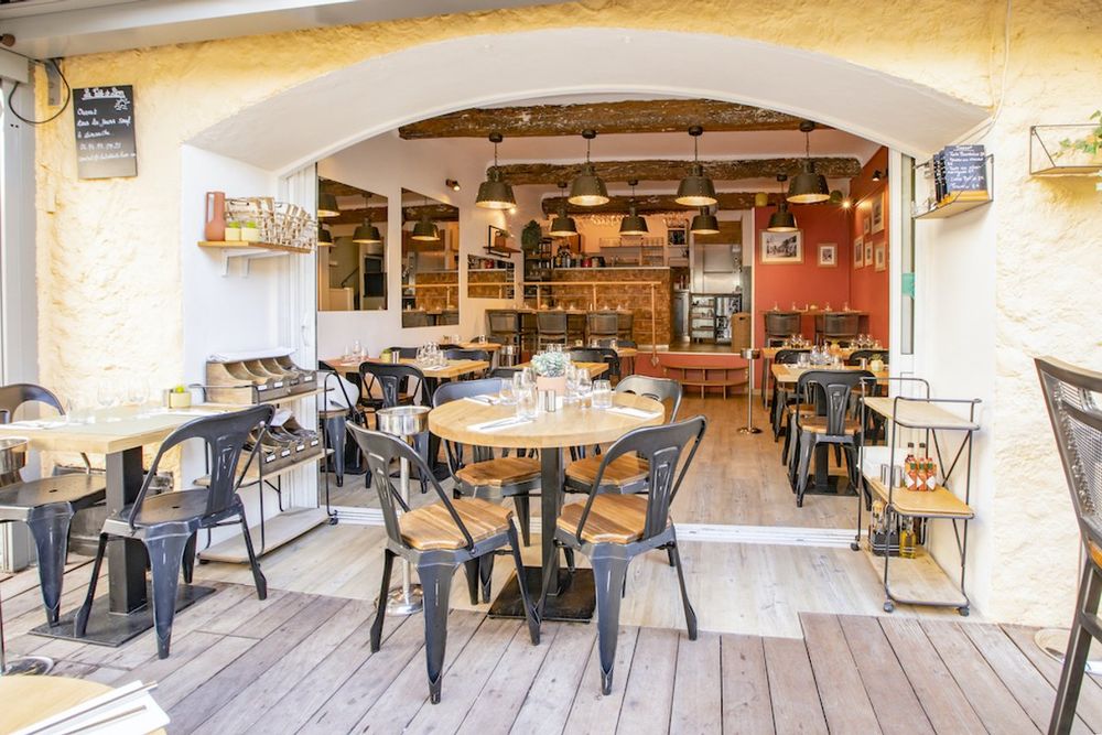 Café tables on the wooden terrace in front of La Table de Léon in a pedestrian street of Saint-Tropez