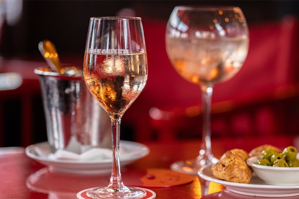 Two glasses of rosé and olives on a red table at Sénéquier