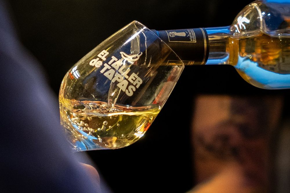 White wine being poured into a glass at El Taller de Tapas