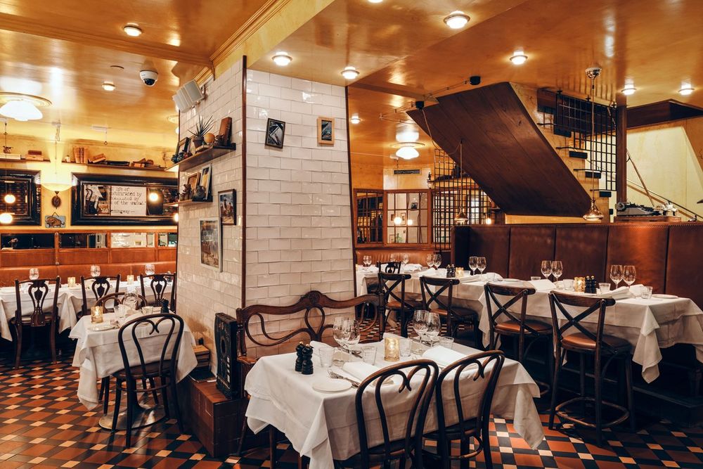 White-clothed tables, bentwood chairs and wood-panelled walls in the dining room at Prinsen