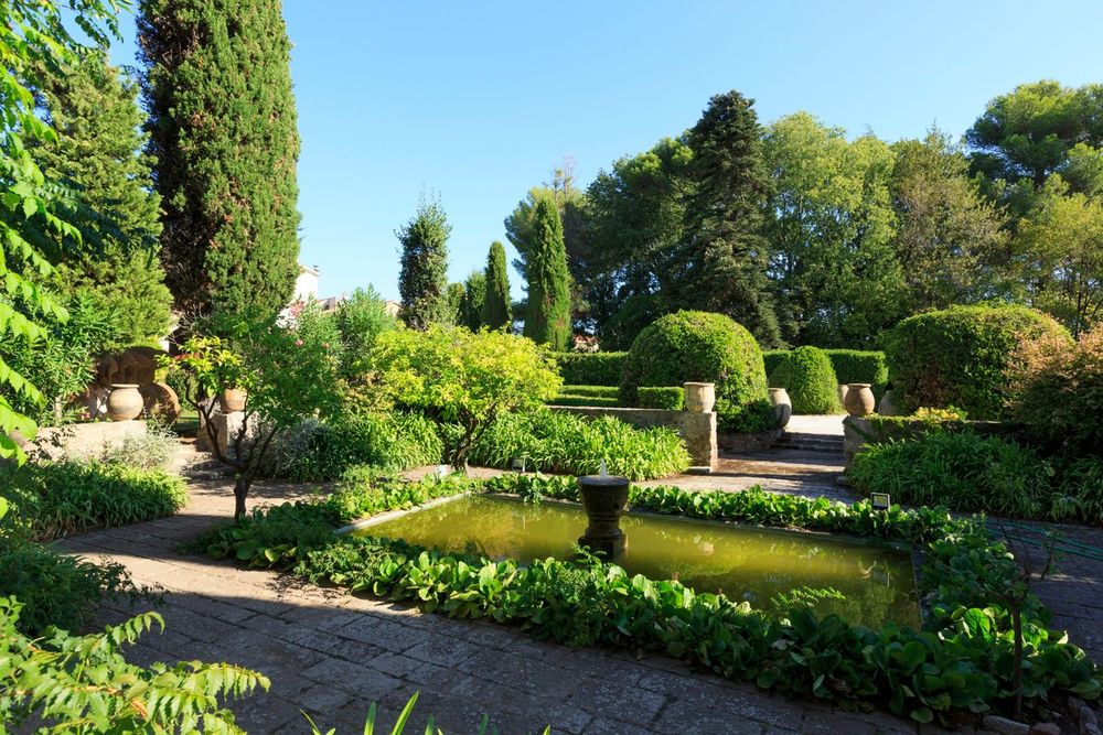 Clipped hedges, cypresses and a formal pool in the gardens of the Château de La Napoule