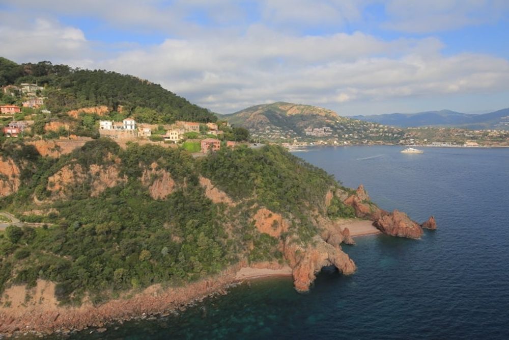 Red rocks, pines and villas on the Théoule coast seen from the heights, with the sea and the bay beyond