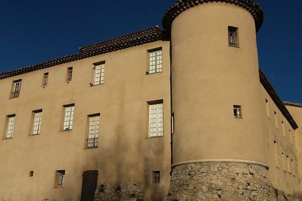 The round tower and ochre walls of the château of Vallauris, home of the Musée Magnelli, against a deep blue sky