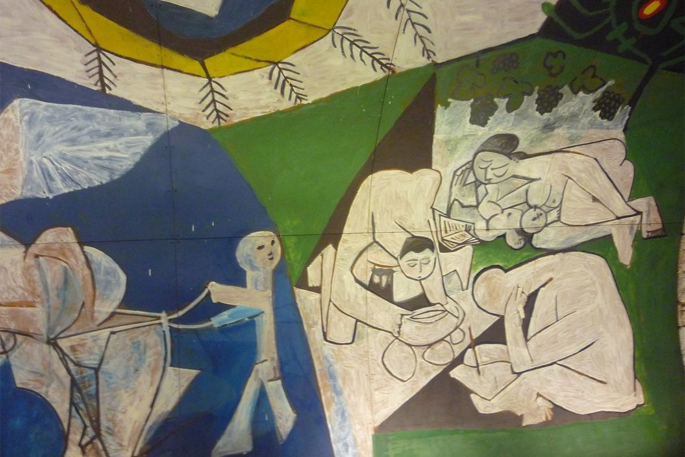Detail of the Peace panel of Picasso's War and Peace in Vallauris: figures reading and resting under a sun-like disc