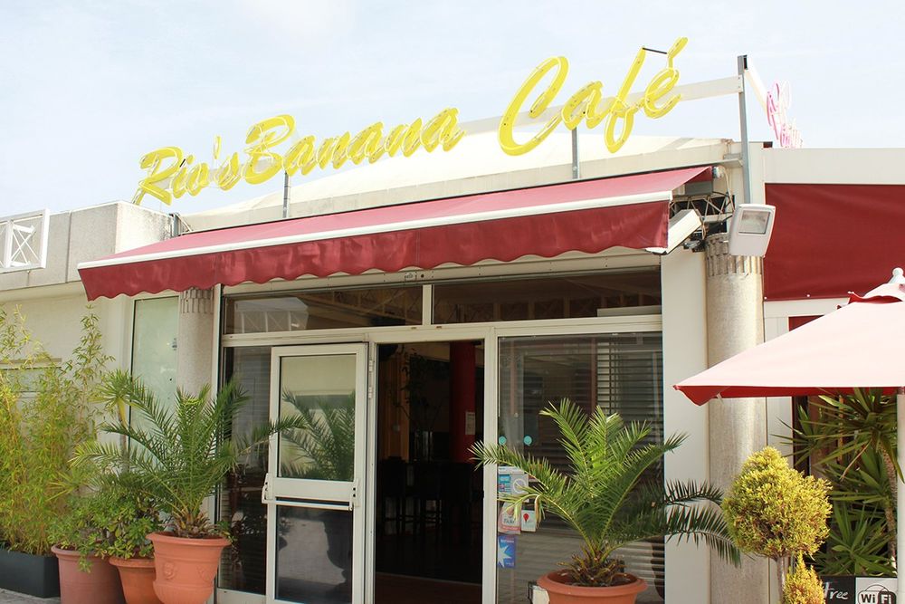 The yellow neon sign and red awning over the entrance of Rio's Banana Café at Port Camille Rayon