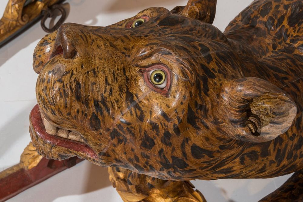 A carved and painted leopard's head on a royal sledge in the Gallery of Coaches, Versailles