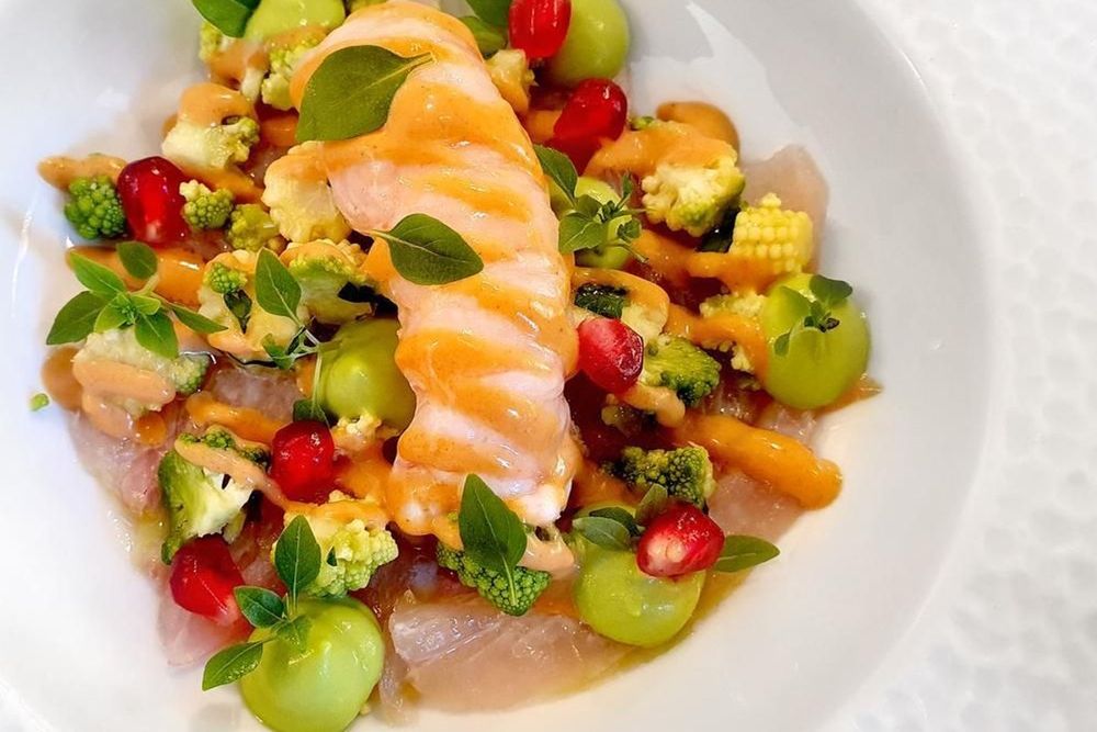 A plate of salmon with small tomatoes, melon and herbs at Le Pincemin, Versailles